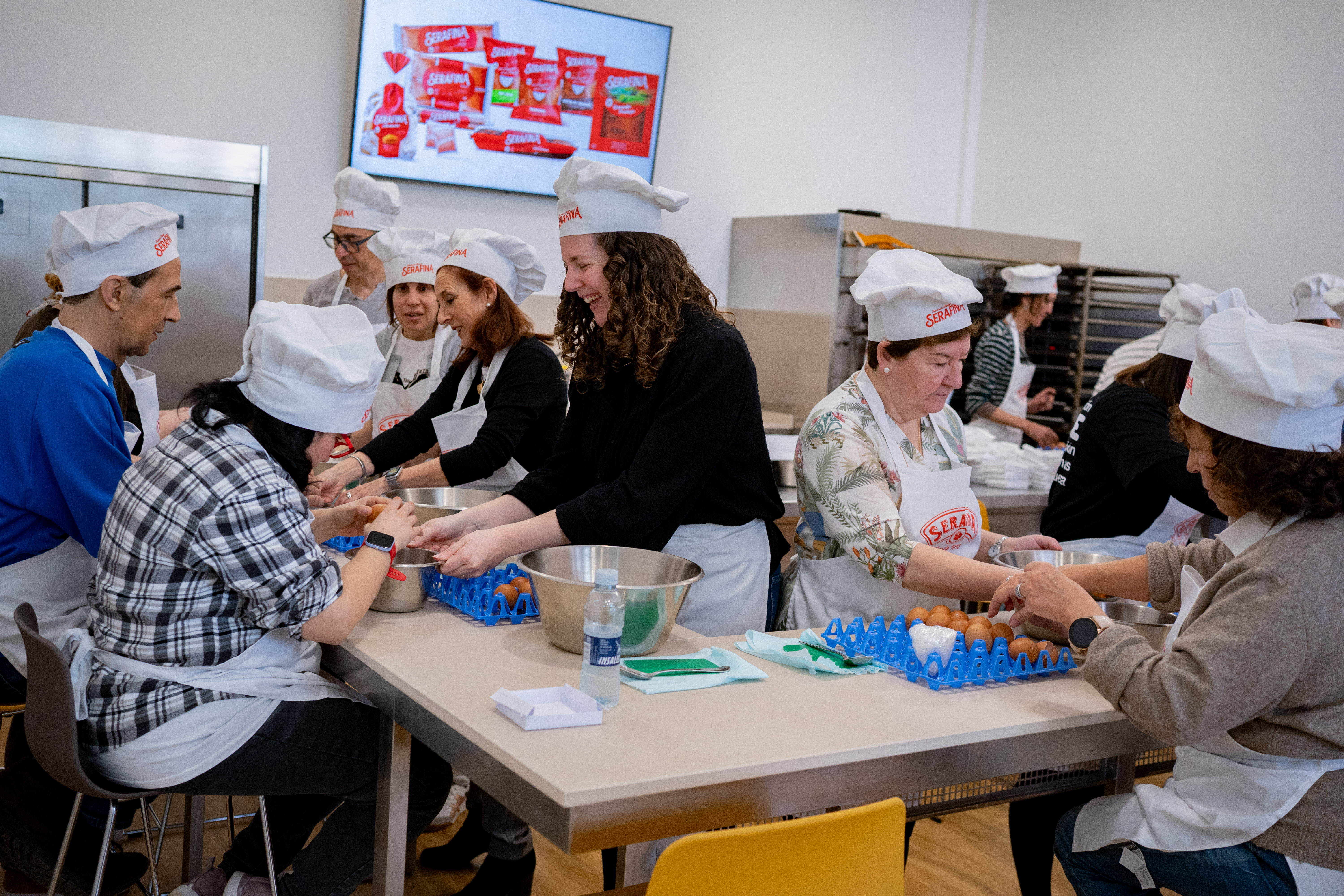 Personas sordociegas junto a empleadas de la empresa y mediadores durante el taller de elaboración de sobaos
