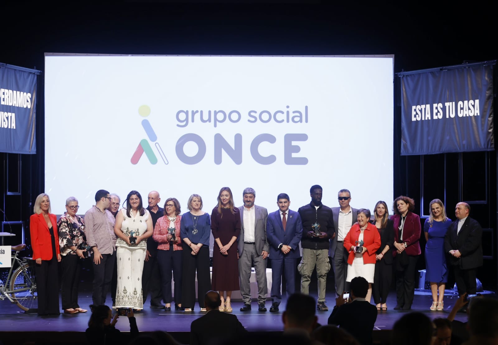 foto de familia de los premiados y autoridades de los Premios Solidarios Grupo Social ONCE Galicia 2025 sobre el escenario del Teatro Colón de A Coruña