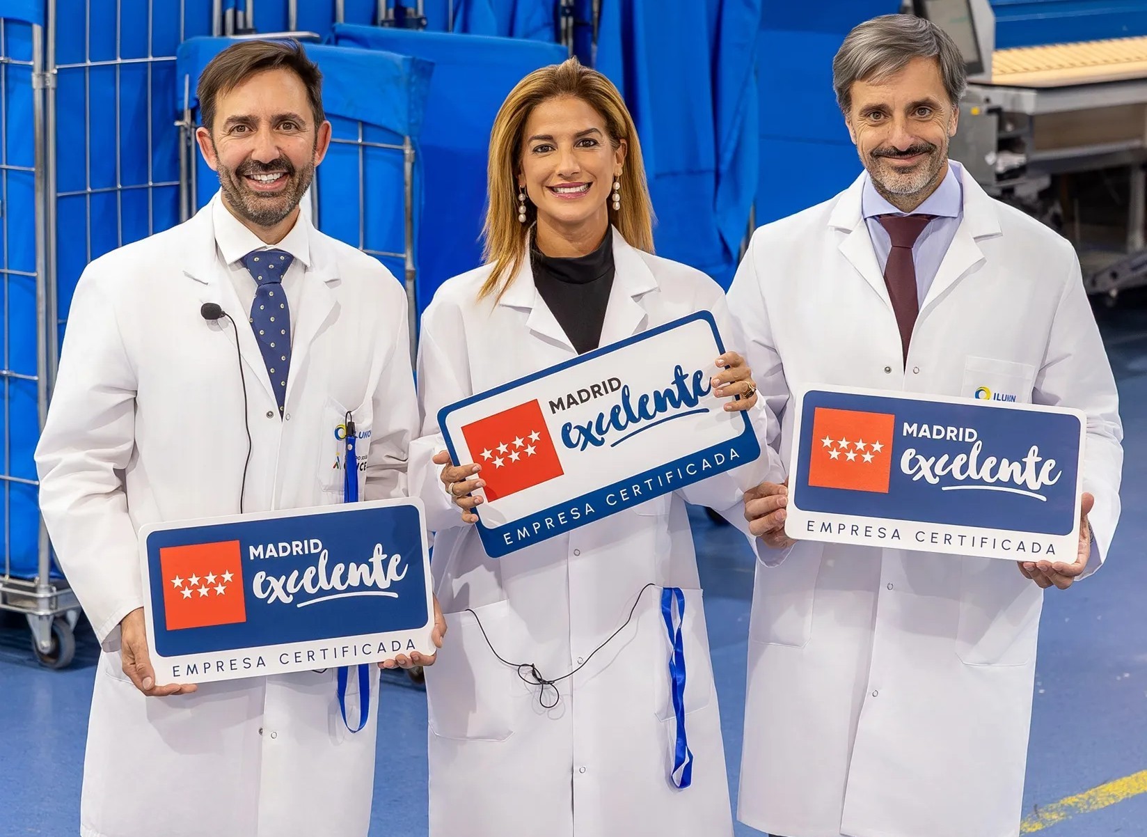Responsables de Ilunion TextilCare junto a Elena Mantilla, en el centro de la imagen, muestra el sello del certificado Madrid Excelente