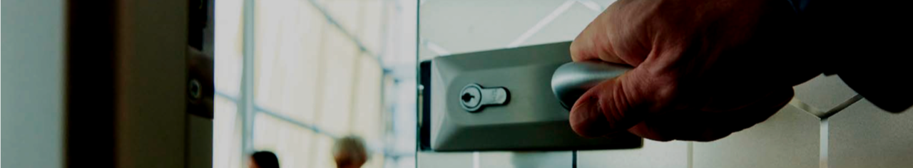 Plano detalle de una mano abriendo la puerta de cristal de un despacho